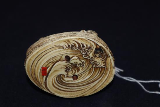 A Japanese ivory okimono netsuke of a dog with a mallet